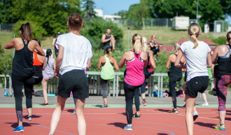 Menschen die im Freien Gymnastikübungen absolvieren.