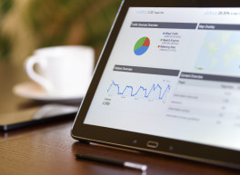 Laptop am Tisch mit Aufzeichnungen der Statistik