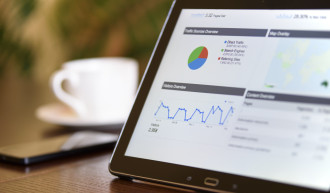 Laptop am Tisch mit Aufzeichnungen der Statistik