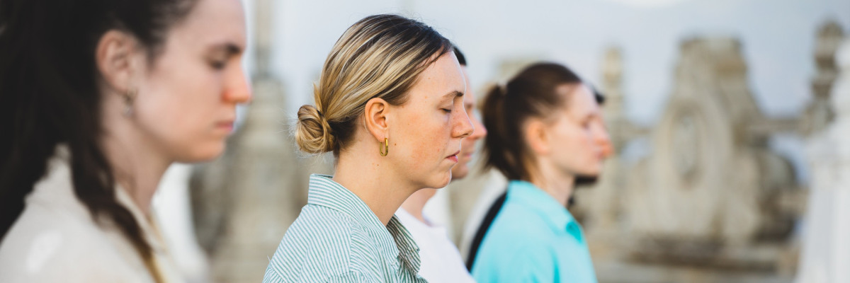 Frauen die gemeinsam meditieren. Die Augen geschlossen haben