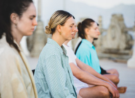 Frauen die gemeinsam meditieren. Die Augen geschlossen haben