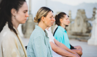 Frauen die gemeinsam meditieren. Die Augen geschlossen haben